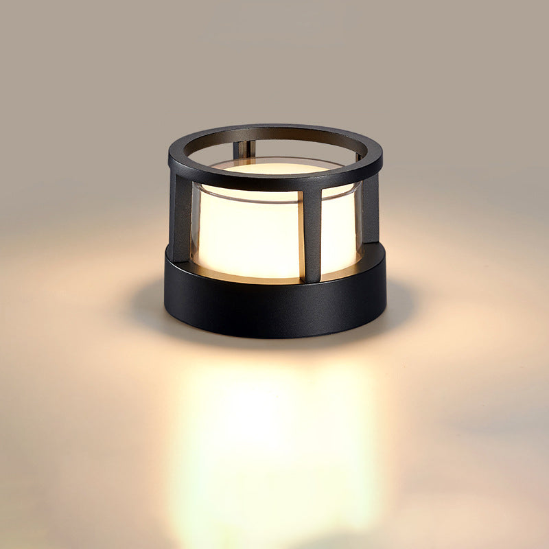 Ronde zwarte lamp met open ringvormige bovenkant en warm licht op een neutrale achtergrond. 9