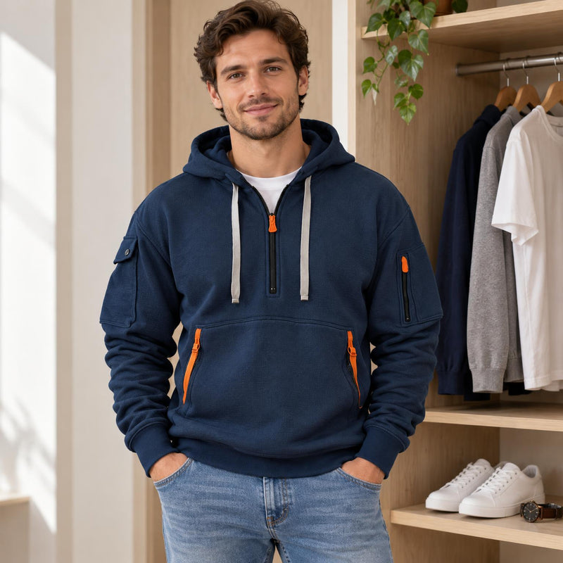 Gevouwen marineblauwe hoodie op een houten plank, naast een horloge en witte sneakers 1