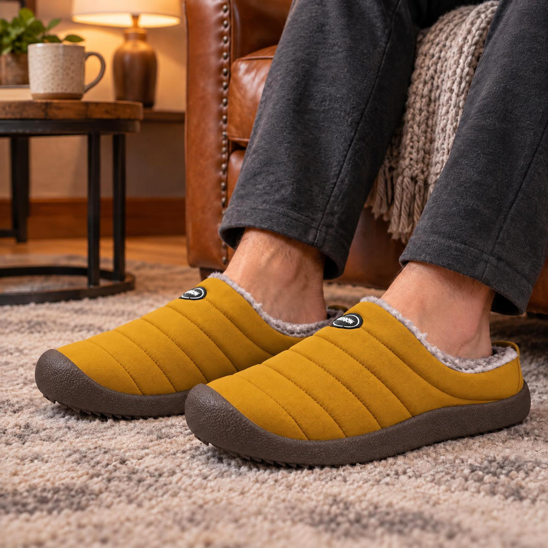 Mosterdgele gewatteerde pantoffels met bruine zool, gedragen op een beige tapijt in een warme woonkamer 5