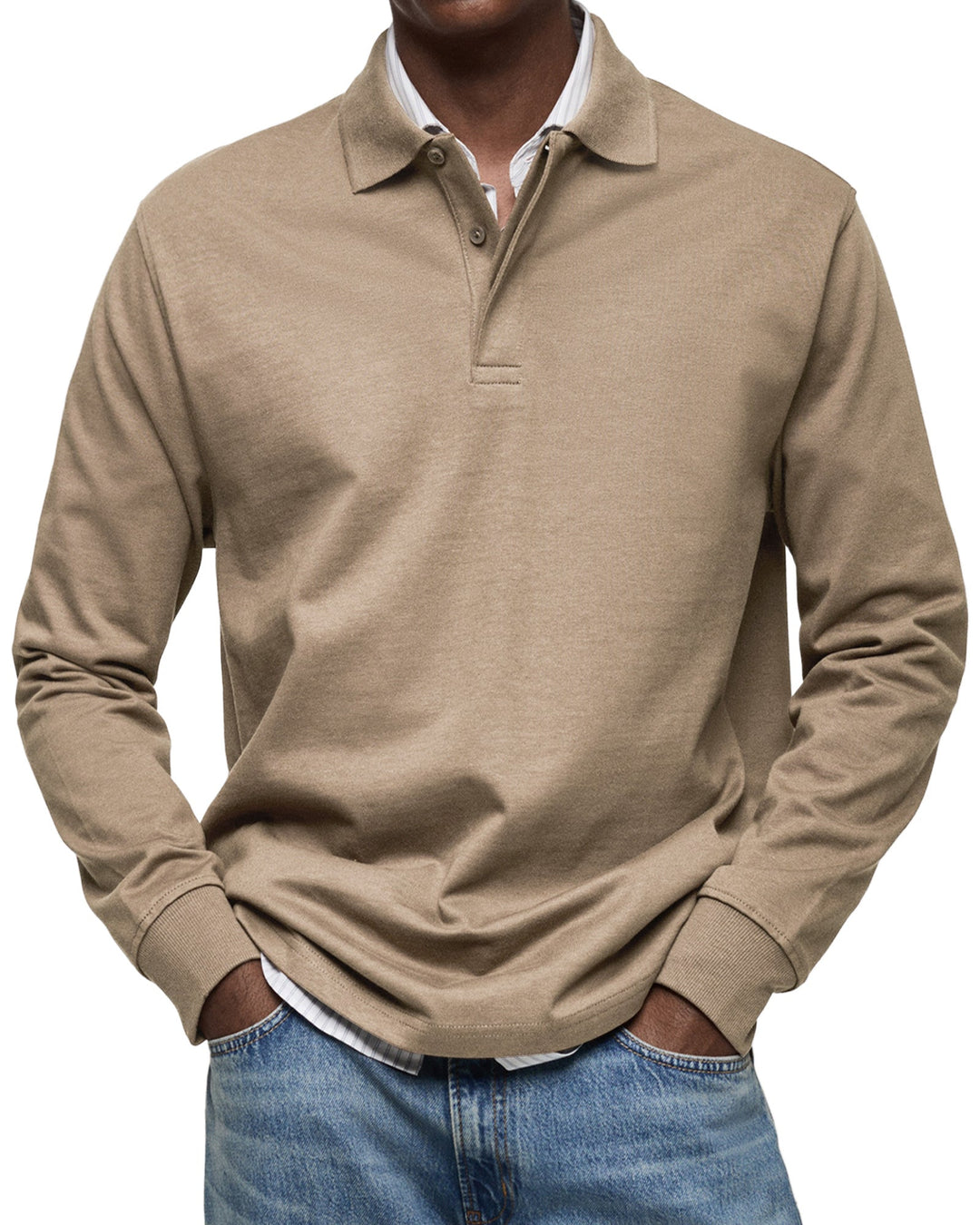 Man draagt het poloshirt met lange mouwen in beigebruin, met handen in de zakken van een spijkerbroek. 8
