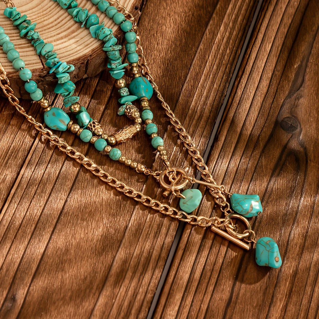 Close-up van de turquoise kralen, steenhangers en gouden kettingen op een houten ondergrond 4