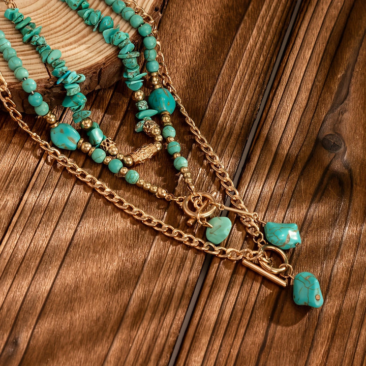 Close-up van de turquoise kralen, steenhangers en gouden kettingen op een houten ondergrond 4