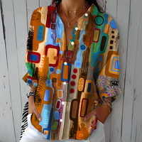Model draagt de blouse in oranje en lichtblauwe tinten met abstract patroon, losse pasvorm en handen in de zakken. 3