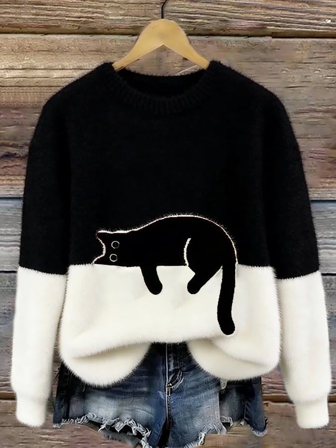 Zwarte pluizige trui met witte onderkant en zwarte kat, aan een hanger voor een houten achtergrond 6