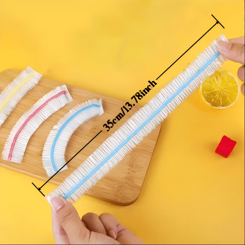 Uitgerekt deksel met blauwe rand wordt vastgehouden, naast drie opgevouwen deksels in geel, rood en blauw op een houten plank. 5