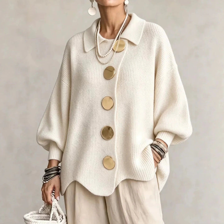 Model draagt het gebreide vest in crèmewit met gouden knopen en een beige broek, vooraanzicht. 4