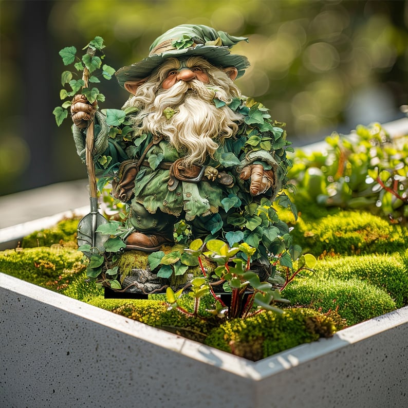 Tuinprikker van de bladerkabouter met schep, geplaatst in een betonnen bak vol mos en kleine plantjes. 15