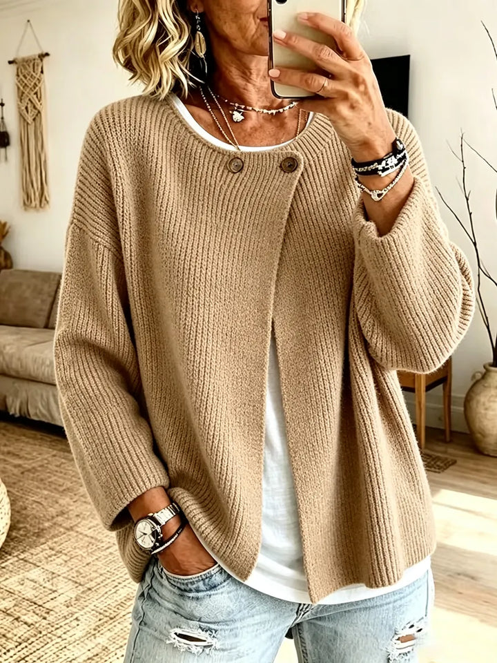 Vest in zandbeige, gedragen met wit shirt en jeans, voorkant met twee knopen bij de hals 1