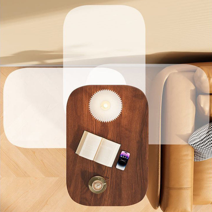 Bovenaanzicht van het notenhouten blad met boek, telefoon, koffiekopje en lamp, met doorzichtige contouren die de draaibeweging naast de bank tonen. 7