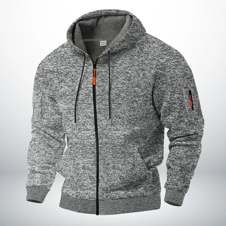 Dezelfde hoodie in gemêleerd lichtgrijs, voorkant met capuchon, trekkoord, oranje ritstrekker en ritszakje op de mouw. 3
