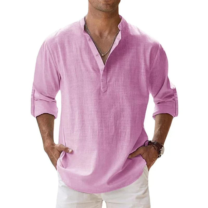 Vooraanzicht van het henleyshirt in roze, gedragen door een man met opgerolde mouwen en handen in zijn zakken. 3