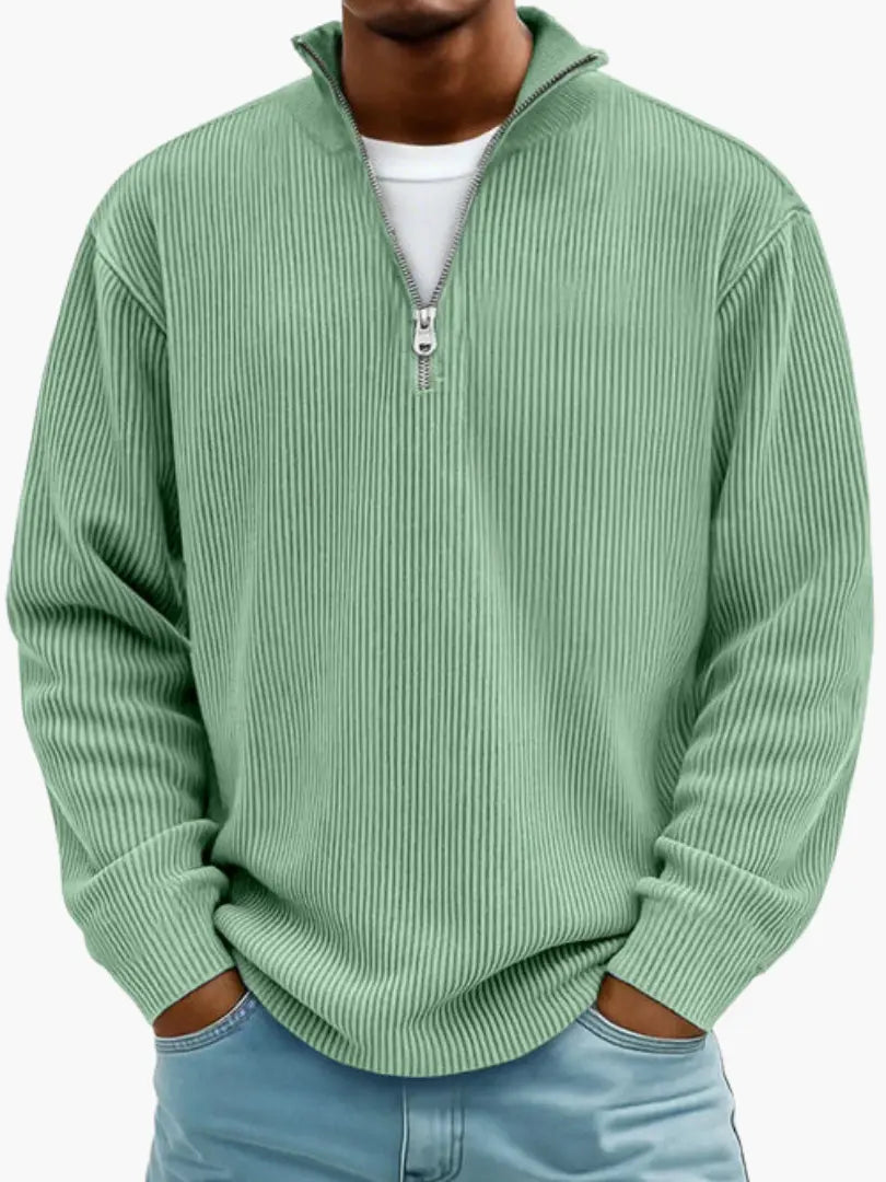 Model draagt de geribbelde trui met kwartrits in mintgroen, met wit shirt eronder en handen in de broekzakken. 3