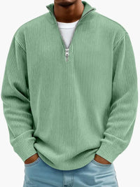 Model draagt de geribbelde trui met kwartrits in mintgroen, met wit shirt eronder en handen in de broekzakken. 3