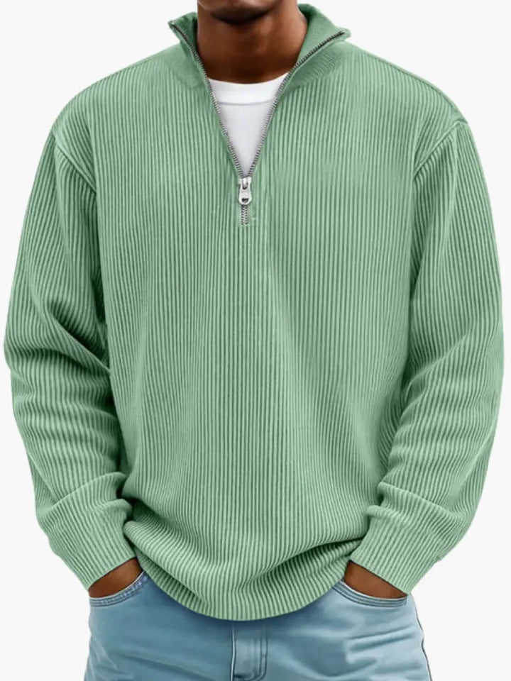 Model draagt de geribbelde trui met kwartrits in mintgroen, met wit shirt eronder en handen in de broekzakken. 3