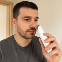 Man met korte baard houdt het apparaat tegen zijn neus om poriën te reinigen 6