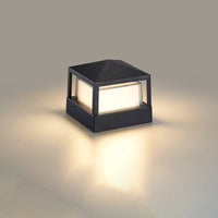 Vierkante zwarte lamp met piramidevormig dak en warm licht op een neutrale achtergrond. 10