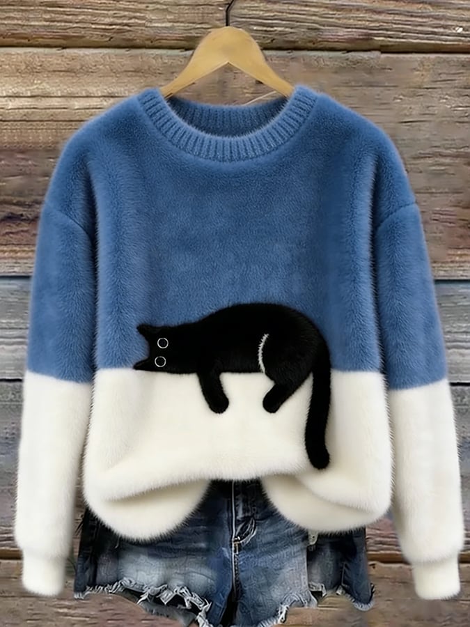 Pluche trui in middenblauw en wit met zwarte kat op de kleurnaad, aan een houten wand 8