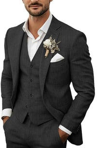 Model draagt het driedelige pak in antraciet met wit overhemd, corsage en pochet, handen in de broekzakken. 6