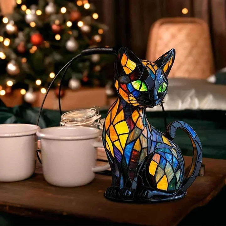 Kattenlampje op een houten tafel naast witte mokken en een kerstboom met lichtjes op de achtergrond 3