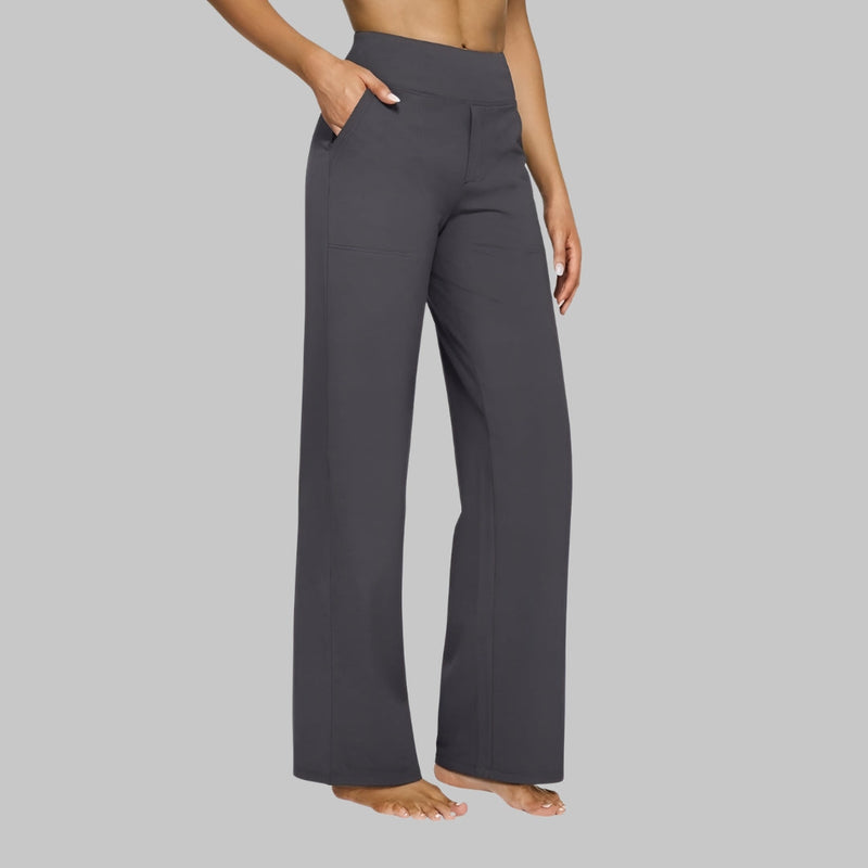 Model in donkergrijze broek met hoge taille en rechte pijpen, zijaanzicht met hand in de zijzak. 6