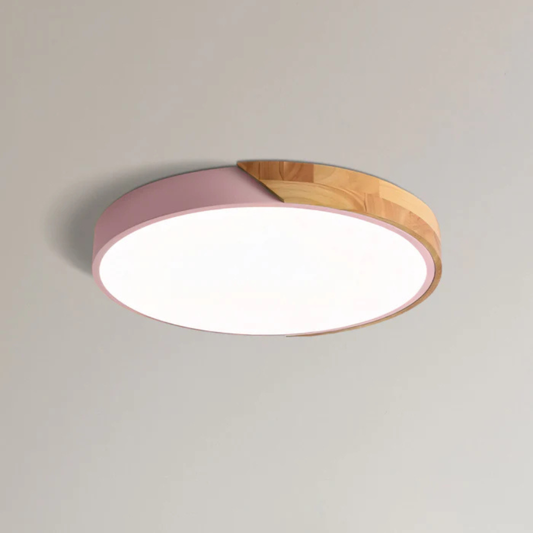 Ronde plafondlamp met roze rand en houten deel, close-up tegen een lichte plafondachtergrond 11