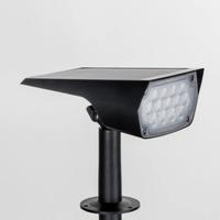 Zwarte tuinspot met zonnepaneel bovenop en led-lampjes aan de voorkant, vrijstaand op een lichte achtergrond. 4