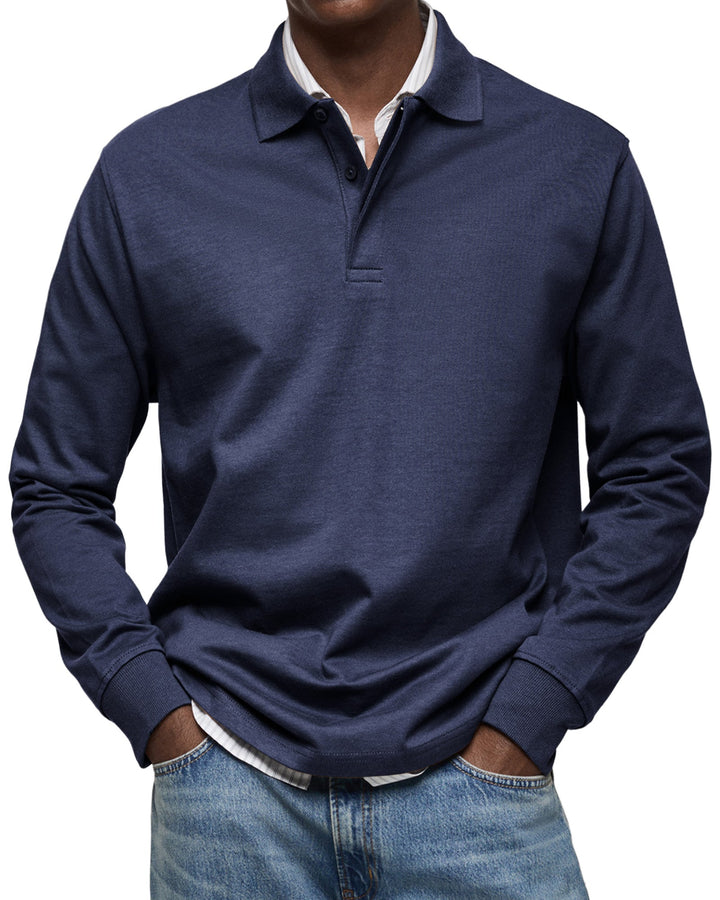 Man draagt het poloshirt met lange mouwen in donkerblauw, met knoopsluiting, ribboorden en een gestreept overhemd eronder. 3