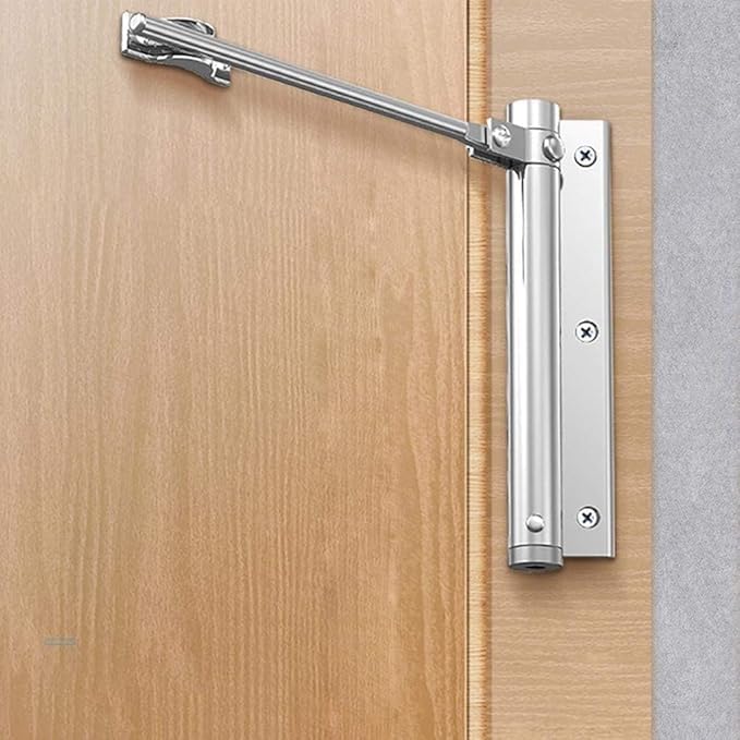 Zilverkleurige veerdeursluiter op een lichte houten deur, gemonteerd aan de scharnierzijde van het kozijn 2