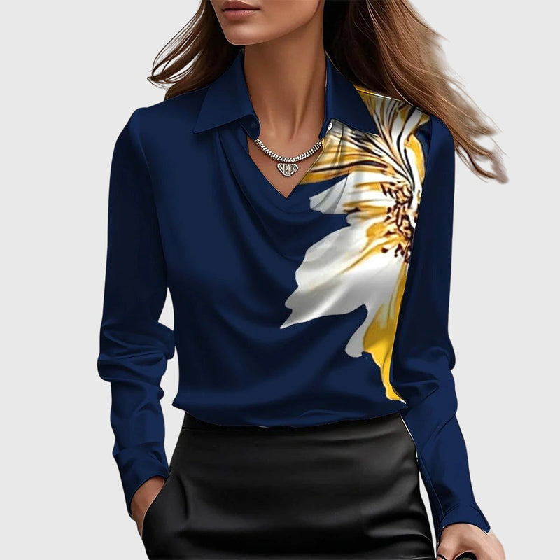 Model draagt de donkerblauwe satijnen blouse met een grote witgele bloemprint op de schouder, gecombineerd met een zwarte rok. 8