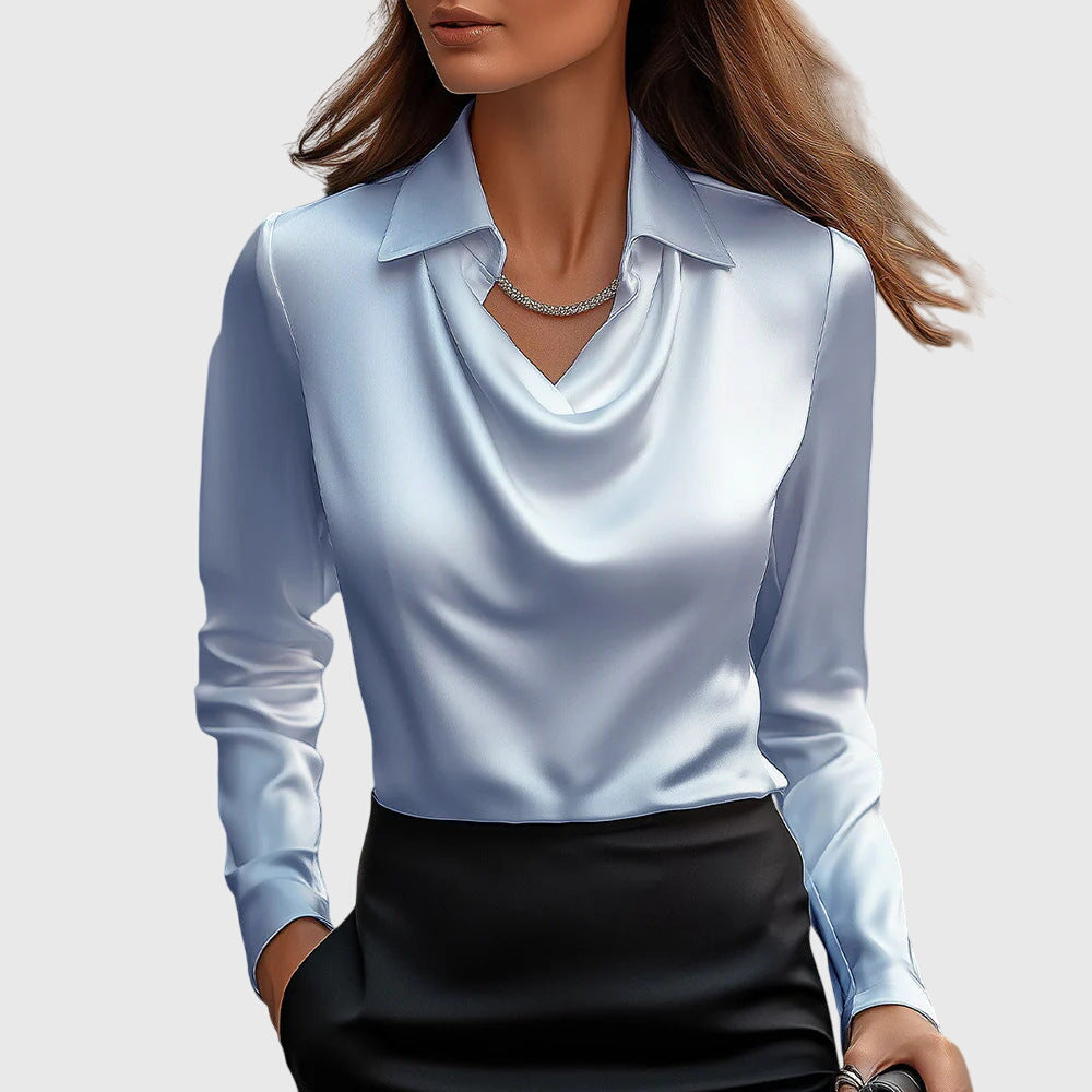 Model draagt de blouse in lichtblauw satijn met gedrapeerde hals en kraag, gecombineerd met een zwarte rok en fijne ketting. 4