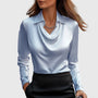Model draagt de blouse in lichtblauw satijn met gedrapeerde hals en kraag, gecombineerd met een zwarte rok en fijne ketting. 4