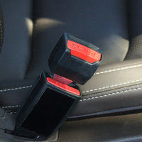 Dop met rode drukknop zit in een gesp tussen de stoelen, close-up in de auto 3