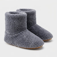 Paar grijze pluizige enkelhoge pantoffels met lichtbruine zool, vrijgesteld op een witte achtergrond. 6