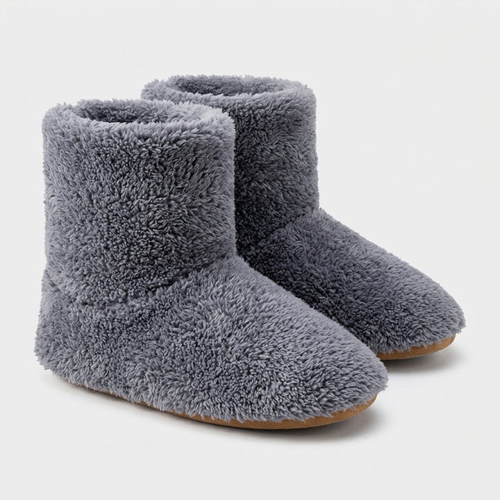 Paar grijze pluizige enkelhoge pantoffels met lichtbruine zool, vrijgesteld op een witte achtergrond. 6