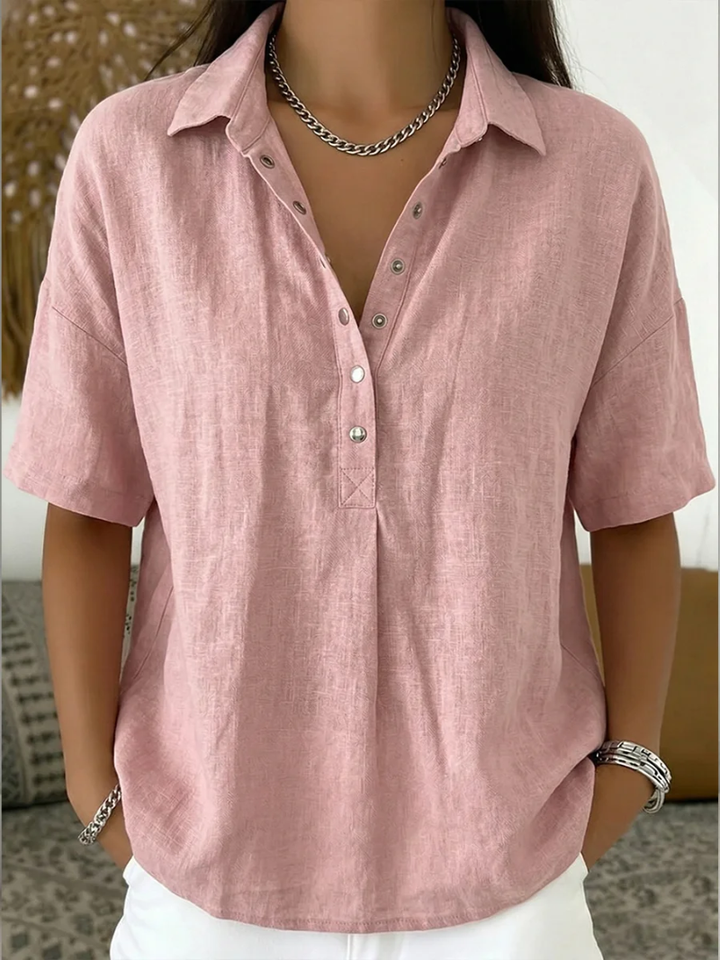 Blouse in zachtroze aan een model, met kraag, korte mouwen en zilverkleurige knopen 5
