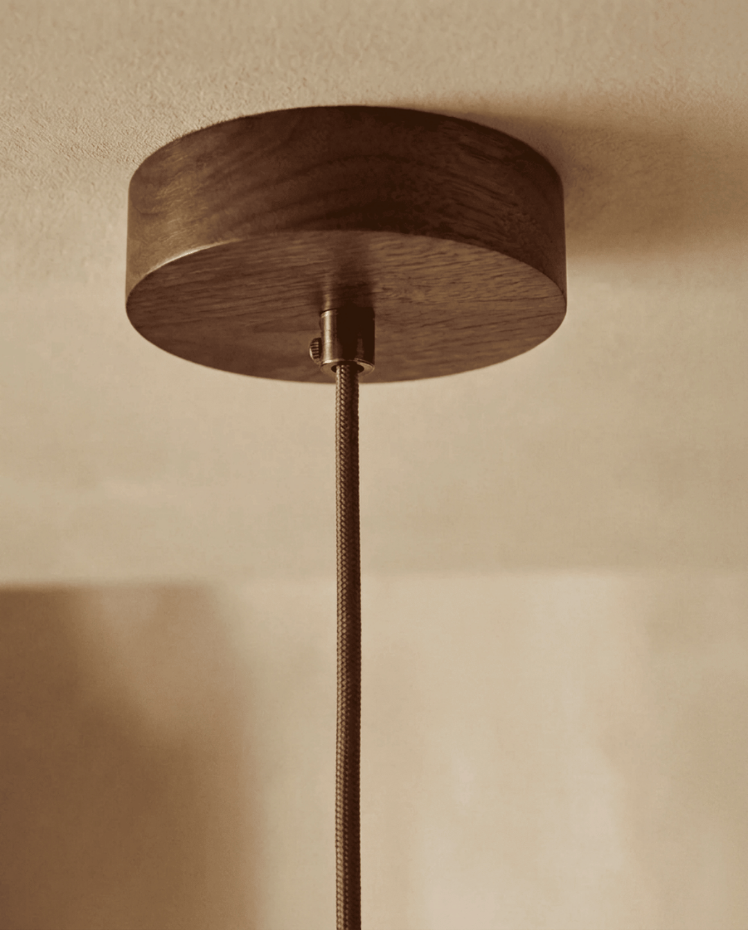 Detail van het ronde houten plafondplaatje met metalen klem en gevlochten snoer 5
