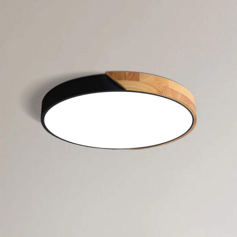 Ronde plafondlamp met zwarte rand en houten deel, close-up tegen een lichte plafondachtergrond 9