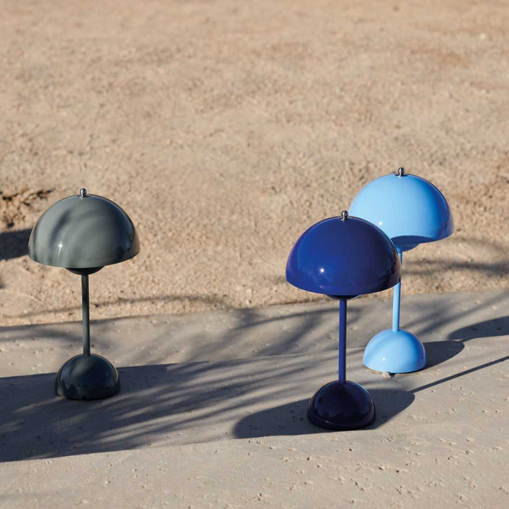 Drie lampen in grijsgroen, kobaltblauw en lichtblauw op een zonnig zandkleurig terras met schaduwen 25