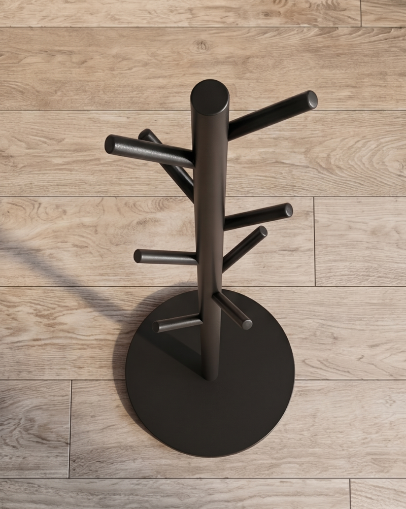 Zwarte kapstok van bovenaf gezien, met de ronde voet en de haken die in verschillende richtingen uitsteken op een houten vloer. 6