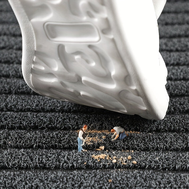 Detail van een witte schoenzool boven de mat, met miniatuurfiguurtjes die losse vuilkorrels tussen de lussen opruimen. 4