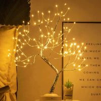 Boomlamp met stralende lampjes in een kamer, naast een klein vetplantje en een ingelijste poster 3