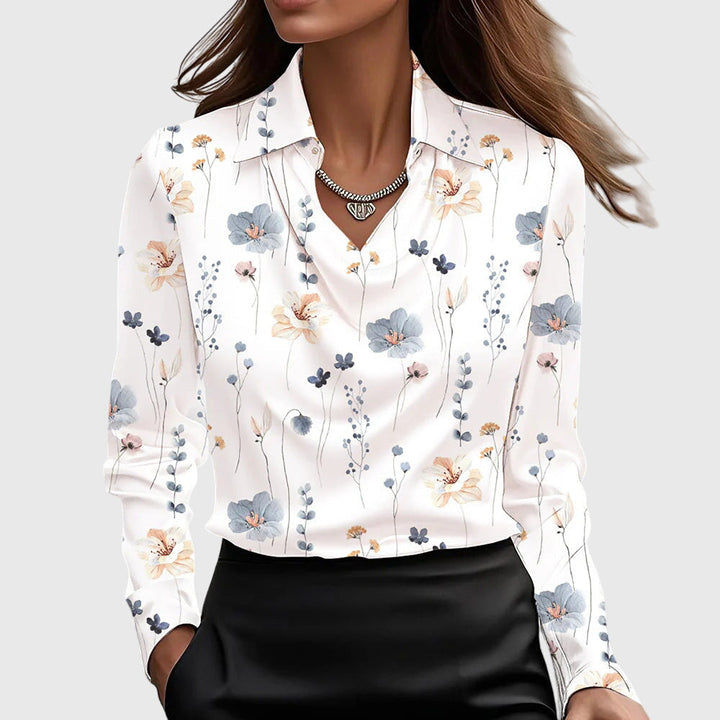 Model draagt de witte satijnen blouse met fijne bloemenprint in blauwe en perzikkleurige tinten, gedrapeerde hals en zwarte rok. 9