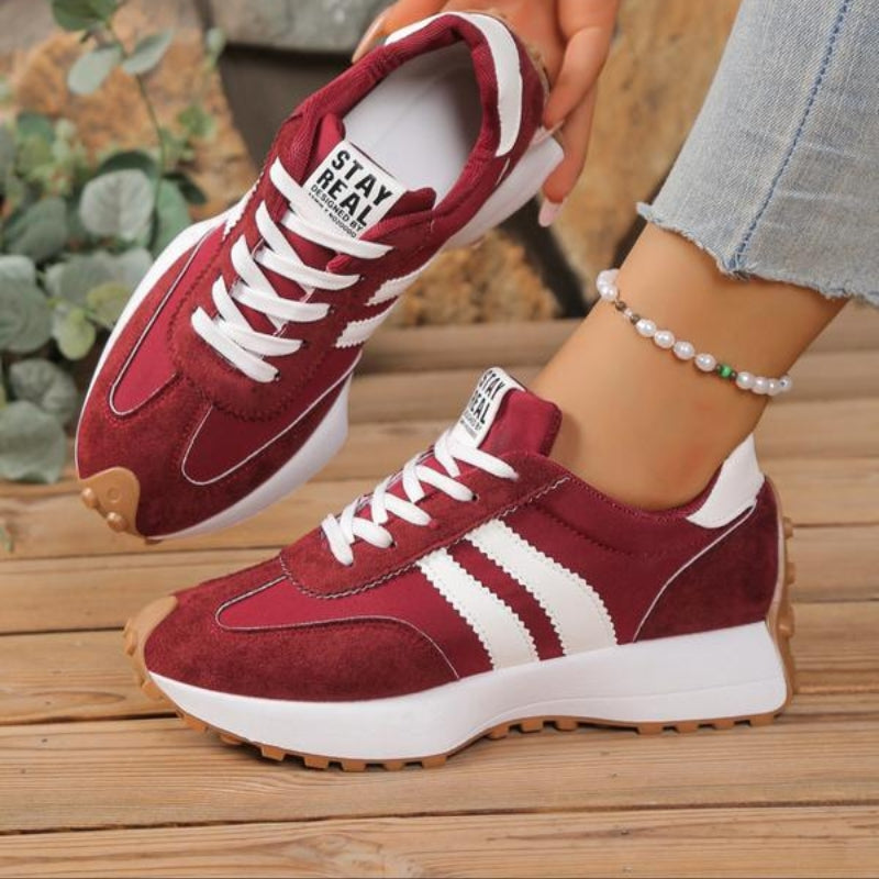 Rode suède sneakers met witte strepen en dikke zool, gedragen door een model bij een jeans 4