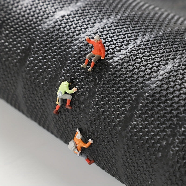 Onderkant van de mat met geweven structuur, waarop miniatuurklimmers in felgekleurde jassen omhoog klimmen. 7