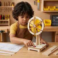 Kind in werkplaats zet met een rode schakelaar een houten ventilator met gele schroefbladen aan, naast bouwtekening en latjes. 2