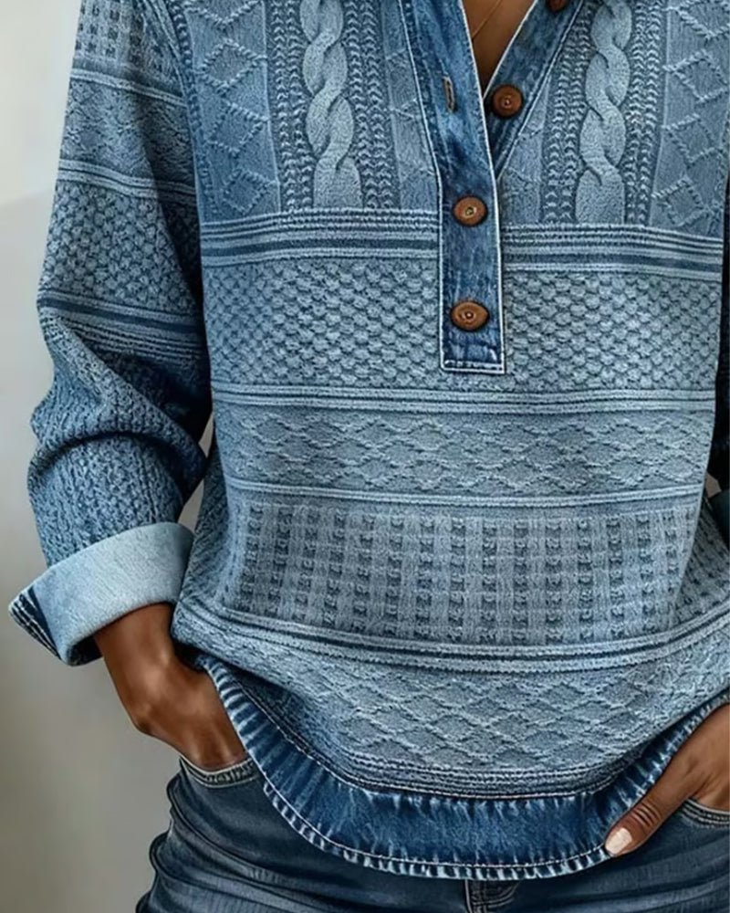 Close-up van de blauwe trui: kabel- en ruitpatronen, houten knopen en omgeslagen denimmouwen 2