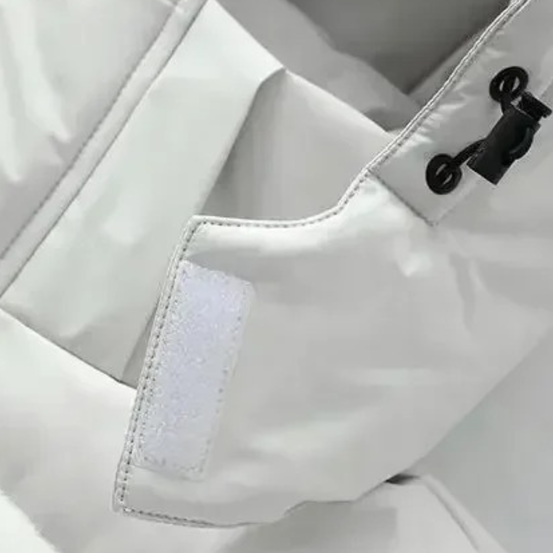 Close-up van de witte jas met klittenbandlipje bij de mouwopening en trekkoord aan de capuchon 5