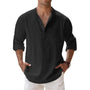 Het henleyshirt in zwart gedragen door een man, met knoopsluiting, opgerolde mouwen en handen in de zakken. 7