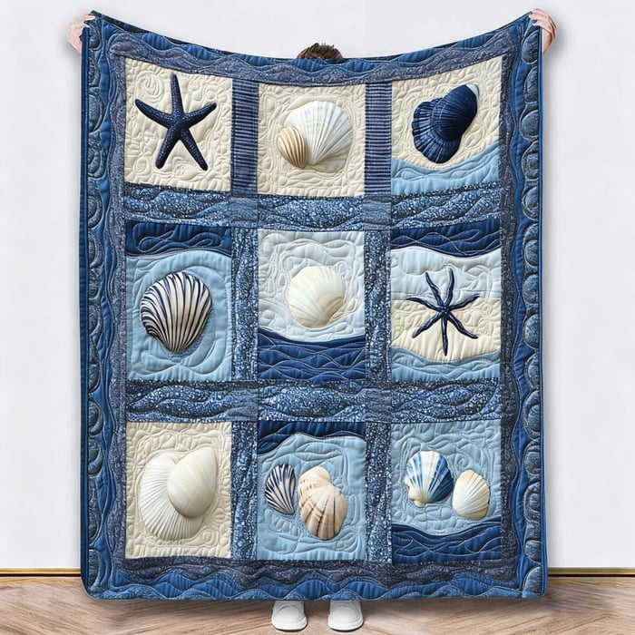 Blauwe deken met schelpen en zeesterren in vakken, omhooggehouden tegen een witte muur 5