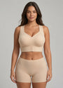 Model draagt de beige steunbeha met brede bandjes en haakjes aan de voorkant, gecombineerd met een beige boxershort, vooraanzicht. 1